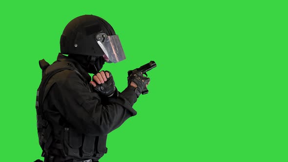 Armed Man in Protective Cask with a Pistol Walking Aiming on a Green Screen Chroma Key