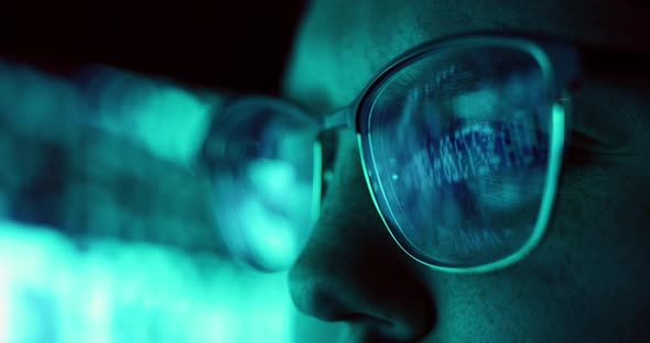 Closeup of Young Adult Female Wearing Reflective Glasses Analyzing Financial Stock Data Code Working