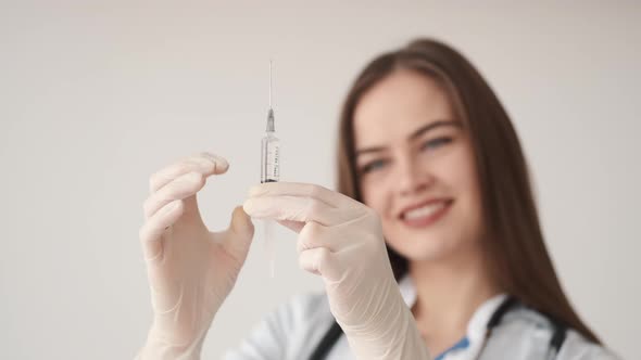 A Young Female Doctor Holding a Medical Syringe