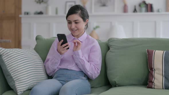 Indian Woman having Success on Smartphone at home