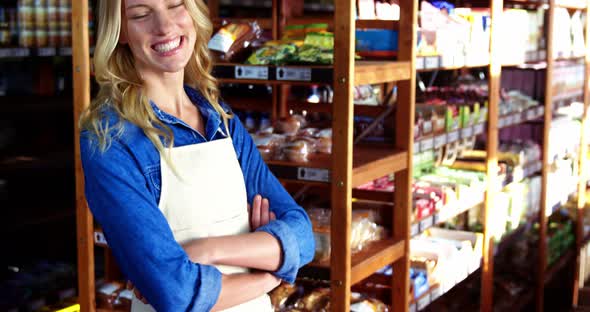 Portrait of smiling female staff standing with hands crossed