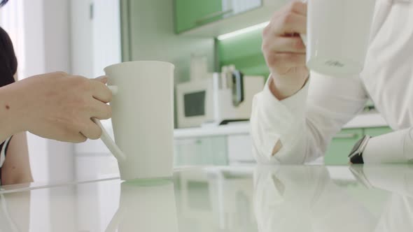 Beautiful Couple Drinking Coffee In The Kitchen. Morning. Close-up.