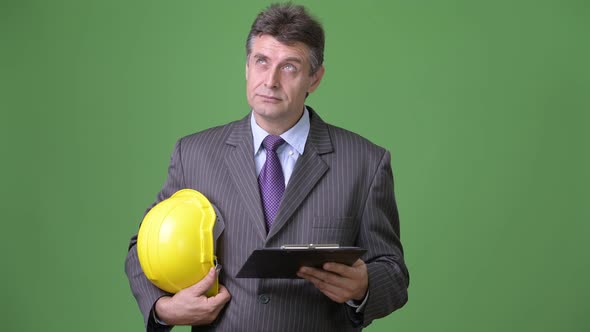 Mature Handsome Businessman Against Green Background