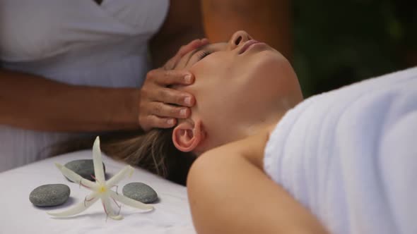 Woman gets massage at outdoor spa, closeup