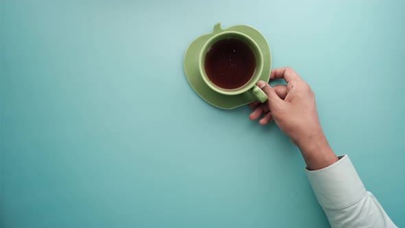 Hand Holding Cup of Green Tea with Copy Space