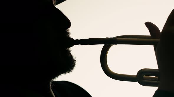Face of Man Playing Trumpet in Studio on White Background Closeup