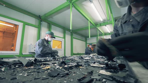 Junkyard Employees Are Inspecting Pieces of Broken Electronics