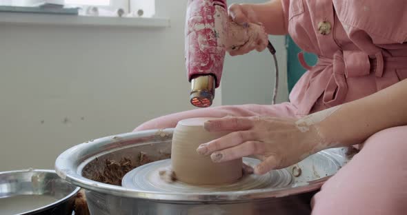 Female Potter Sitting and Firing a Shape Cup Clay on the Pottery Wheel. Woman Making Ceramic Item