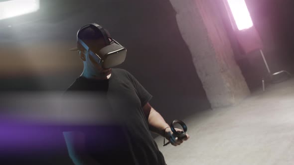 Male Gamer In VR Headset Holding Controllers