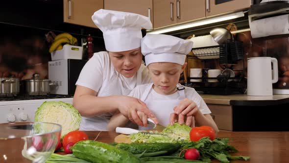 Mother with Her Son Prepare Vegetable Salad Together Cut Fresh Cabbage