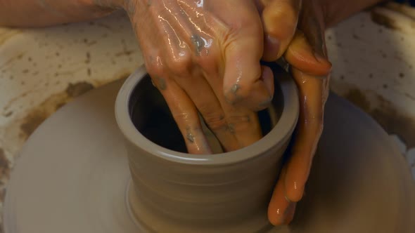 Potter making a earthen pot on a pottery wheel