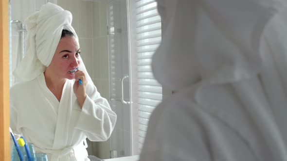 Happy Young Woman Holding Toothbrush Brushing Teeth Looking in Mirror