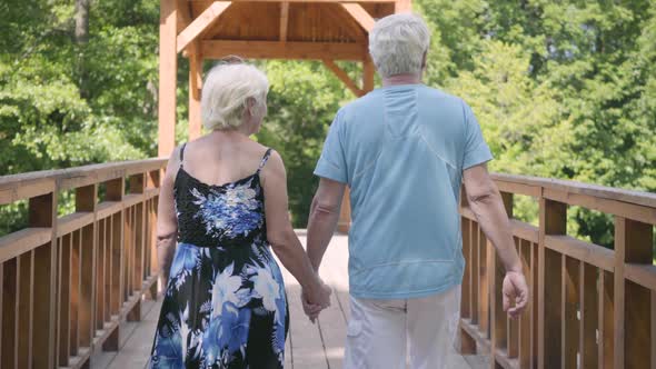 Mature Couple Walking on the Bridge Holding Hands