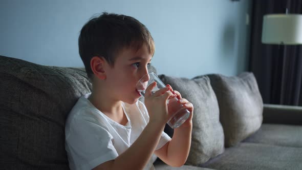 Cute Little Baby Boy Drinking a Glass of Water in Home