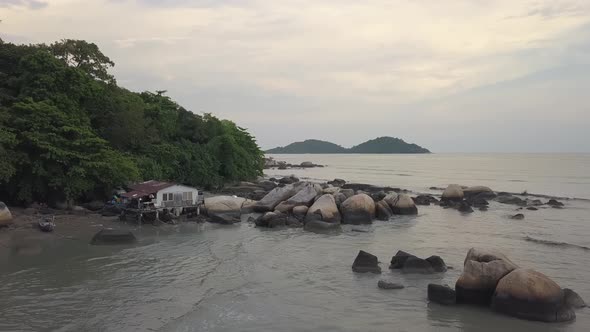Wooden fisherman house near rocky stone at beach / Videohive