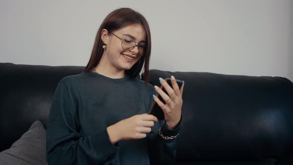 The Optimistic Happy Girl Talks in a Video Call with Her Friends on the Phone at Home