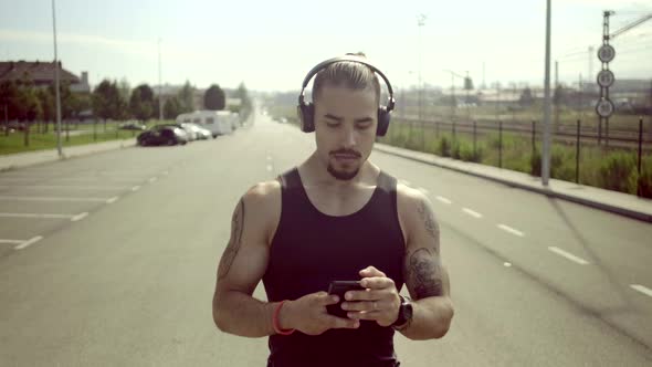 Athlete with headphones walking on the street