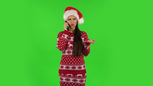 Sweety Girl in Santa Claus Hat Is Angrily Talking for Mobile Phone. Green Screen