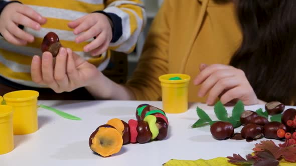 Mother and Child Sculpt Autumn Craft Caterpillar From Chestnuts and Plasticine