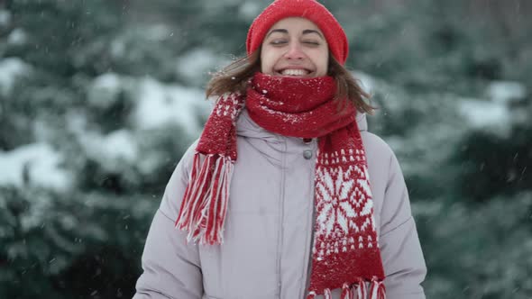 Slow Motion Camera Tracking Shot of Happy Pretty Woman in Red Mittens and Hat Walks in Fir Woods in