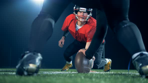 Two American Footbal Players Stand on a Field Against Each Other To Play American Football