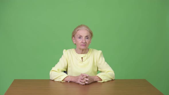 Beautiful Happy Senior Businesswoman Smiling Against Wooden Table