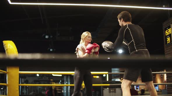 Handsome Coach Teaching Fit Girl in Sport Club. Sport Woman Boxing at Gym