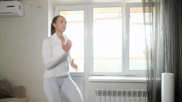 Woman in Suit Jogs in Place Training at Home on Sunny Day