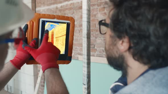 Foreman and Contractor Using Infrared Camera on Tablet Pc