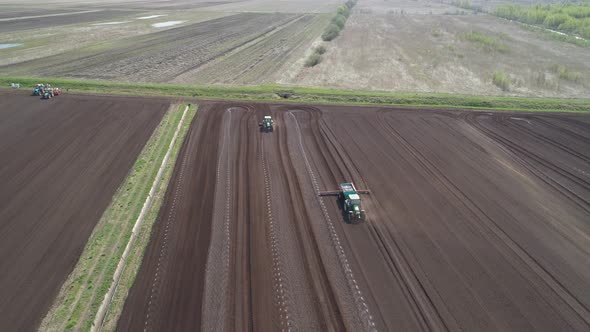 Tractor on Agricultural Lands Is Cultivated with Fertilizers