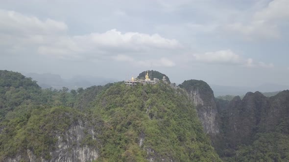 Aerial footage of Buddha on top of Tiger Cave Temple, Wat Thum Sua, stone rocks, Krabi, Thailand