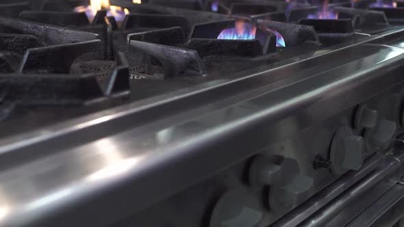 Moving Up Along Gas Stove with Burning Flame on Burners