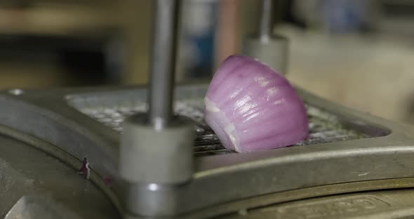 Chopping red onion with a machine.