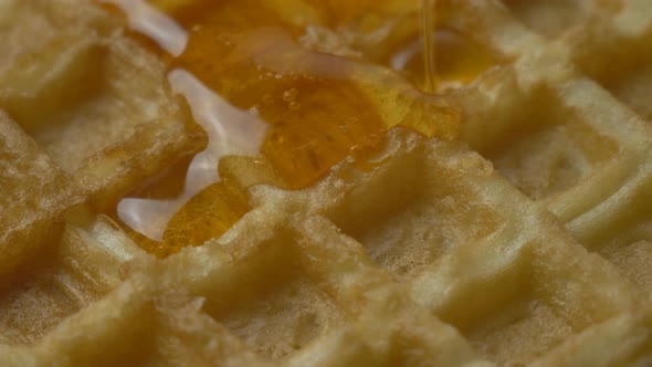 Pouring Maple Syrup on Delicious Belgian Golden Waffles