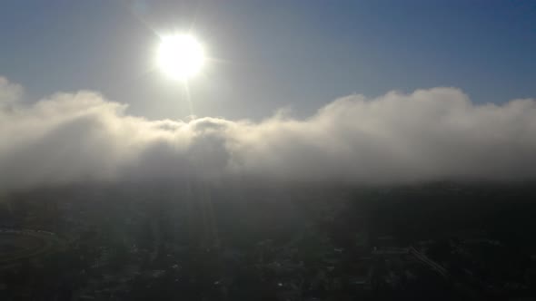 Aerial view of low fog over mountains in San Diego during sunrise