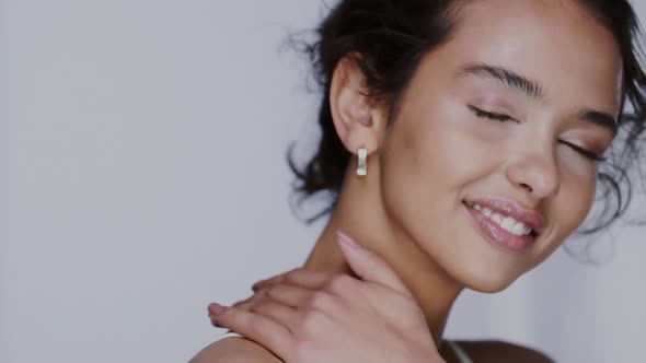 Pretty Girl on Grey Background Touching Her Neck and Smiling