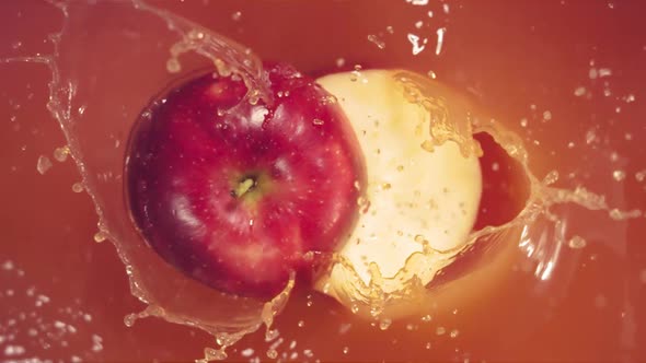 Red Apple Falling on Juice with Splash and Divided in Half