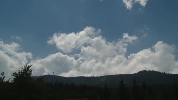 Time-lapse of clouds on blue sky over mountain