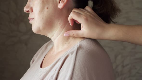 Dermatologist Examines a Mole on a Woman's Neck