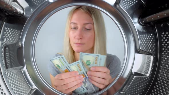 housewife counts money near washing machine and leaves them to wash.