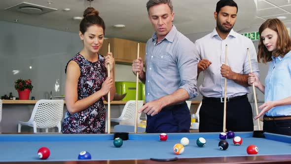 Executives playing pool in office
