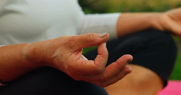 Senior woman performing yoga in garden 4k