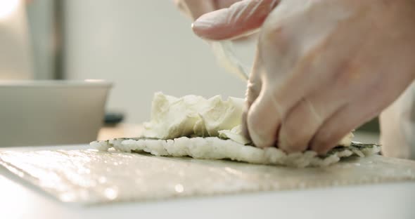 Restaurant Kitchen. Male Sushi Chef Prepares Japanese Sushi Rolls of Rice, Salmon, Avocado and Nori