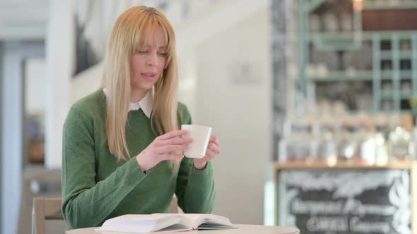 Pensive Young Woman Drinking Coffee in Cafe