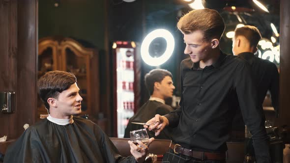 Client Drinking Whiskey Talking with Barber