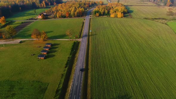 Aerial view of car driving in road beetheen agricultural fields, Estonia.