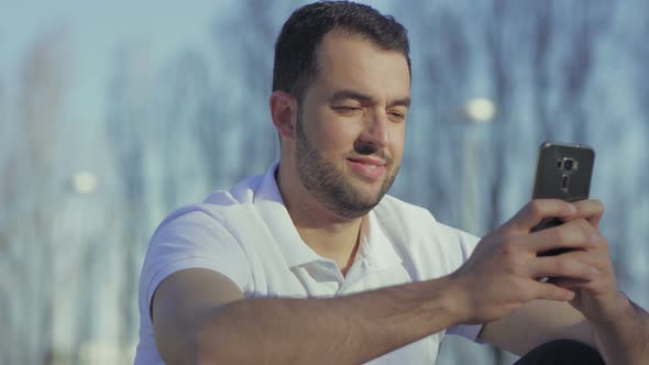 Smiling Bearded Man with Smartphone During Summer Sunny Day