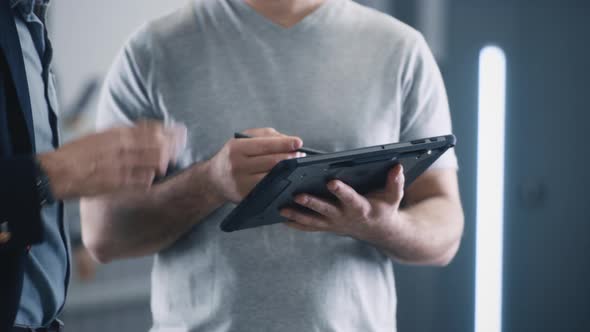 Mechanic with a Tablet Consulting a Client