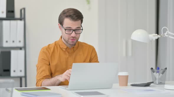 Video Chat on Laptop By Young Man in Office