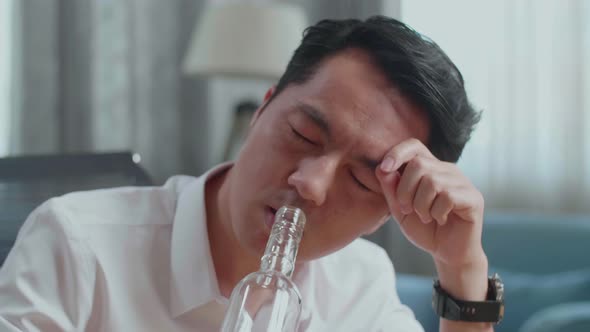 Close Up Of Drunk Asian Man Drinking Vodka At Home